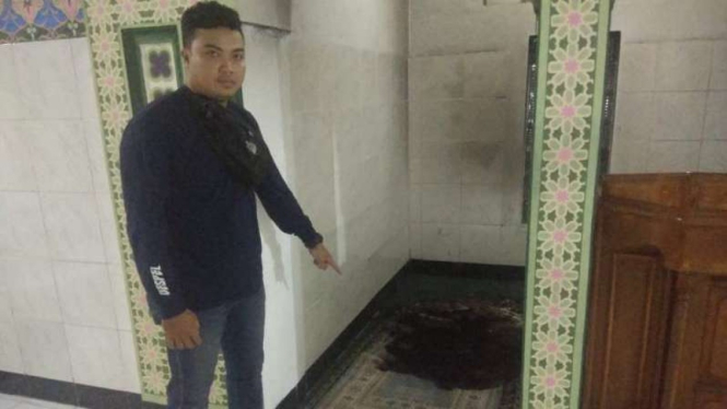 Seseorang membakar sajadah di masjid.