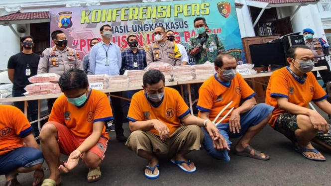 Polisi menunjukkan para tersangka pemalsu uang dan barang bukti uang palsunya di Markas Polrestabes Surabaya, Jawa Timur, pada Kamis, 5 November 2020.