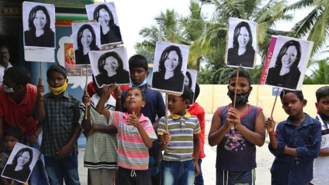 Anak-anak India memegang papan dengan wajah Wakil Presiden terpilih AS Kamala Harris dalam perayaan kemenangannya.