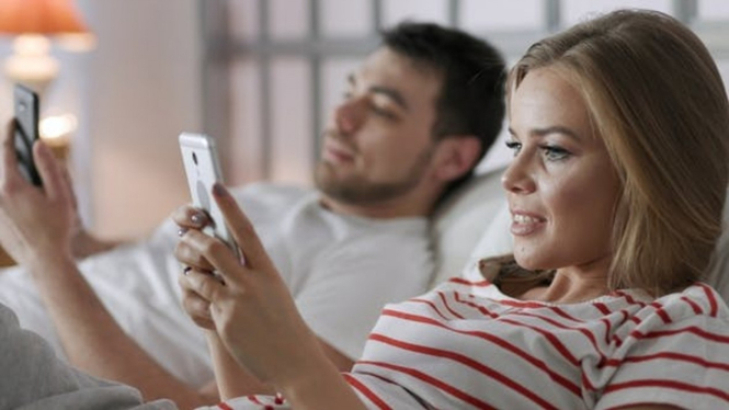 Ilustrasi pasangan asyik dengan smartphone masing-masing.