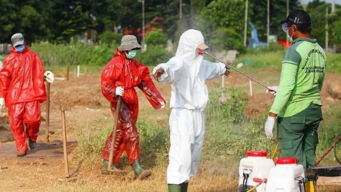 Petugas pemakaman jenazah COVID-19 di TPU Tegal Alur mengenakan APD dan menjalani protokol khusus cegah virus corona.