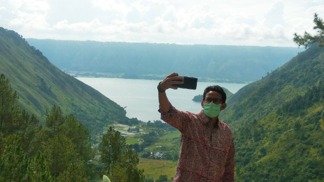 Menteri Pariwisata dan Ekonomi Kreatif Sandiaga Salahuddin Uno berswafoto dengan latar di Danau Toba, Parapat, Kabupaten Deli Serdang, Sumatera Utara, Kamis, 31 Desember 2020.