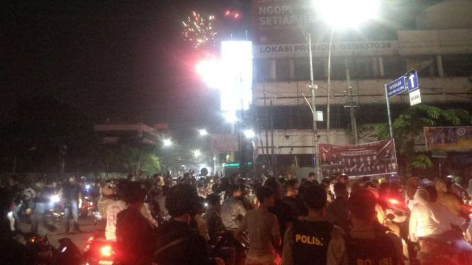 Kerumunan ratusan warga yang merayakan tahun baru dengan menyalakan kembang api di Medan, Sumatera Utara, sebelum dibubarkan oleh aparat pada Jumat dini hari, 1 Januari 2021.