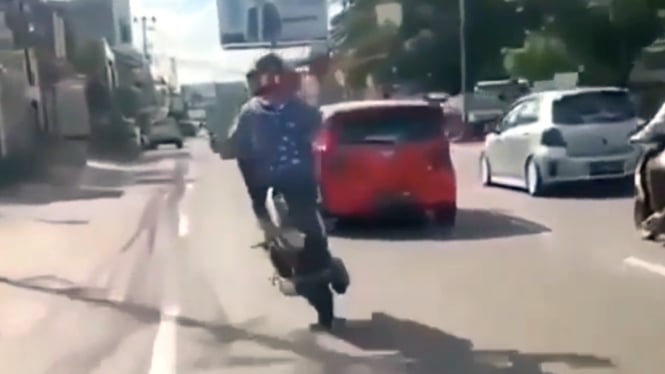 Pengendara motor beratraksi di jalan raya