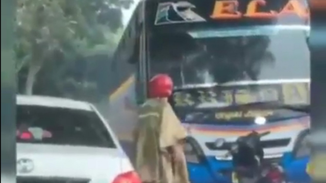Pengendara motor mengadang bus yang nekat melawan arus