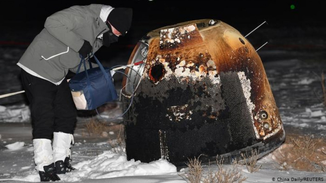Seorang ilmuwan mengambil kapsul dari Chang'e-5 yang berisi sampel Bulan.
