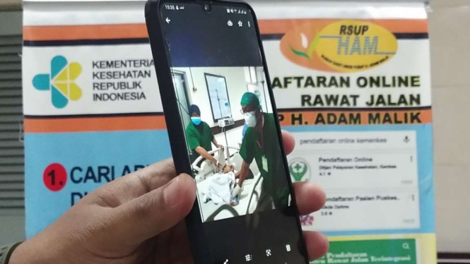Seorang petugas kesehatan menunjukan foto Adam dan Aris akan menjalani operasi.