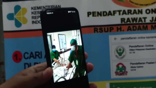 Seorang petugas kesehatan menunjukan foto Adam dan Aris akan menjalani proses