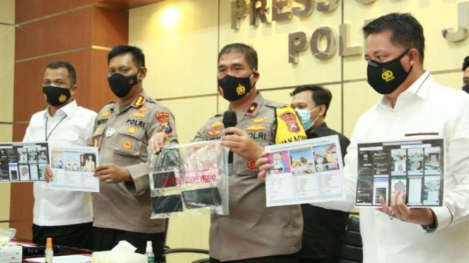 Polisi memperlihatkan tersangka Om Kos (baju tahanan biru) dan barang bukti dalam kasus prostitusi anak di Mojokerto dalam konferensi pers di Markas Polda Jawa Timur, Surabaya, Senin, 1 Februari 2021.