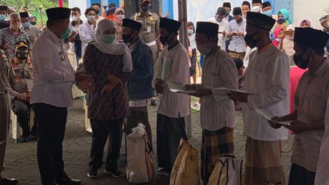 Gubernur Jawa Timur Khofifah Indar Parawansa menyerahkan sertifikat tanah kepada pengungsi eks pengikut Syiah di Rusunawa Jemundo, Sidoarjo, pada Selasa, 2 Februari 2021.