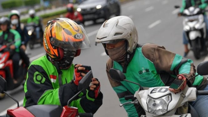 Ilustrasi dua orang pengemudi ojek online (ojol) berbincang di Jalan.