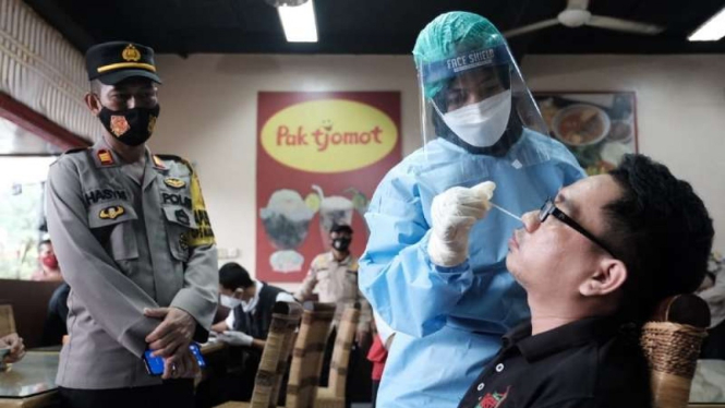 Seorang pelanggar protokol kesehatan pencegahan penularan COVID-19 di Kabupaten Gowa, Sulawesi Selatan, di-rapid test antigen dalam operasi yustisi yang dipimpin Bupati pada Rabu, 3 Februari 2021.