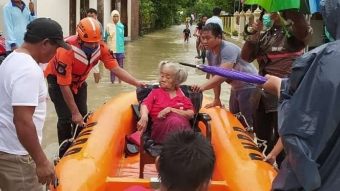 Tim penyelamat BPBD mengevakuasi seorang perempuan lansia yang terdampak banjir di Kabupaten Kendal, Jawa Tengah, pada Minggu, 7 Februari 2021.