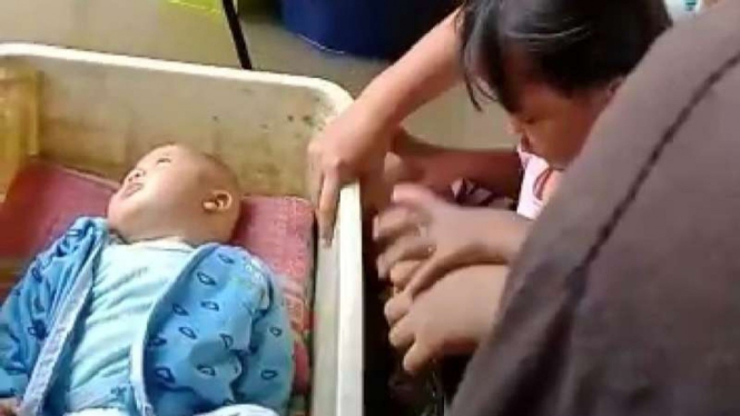 Dua bayi yang masih berusia enam bulan terjebak banjir di Kampung Kali Ulu Desa Tanjung Sari, Kecamatan Cikarang Utara, Kabupaten Bekasi, Jawa Barat, Minggu, 7 Februari 2021.