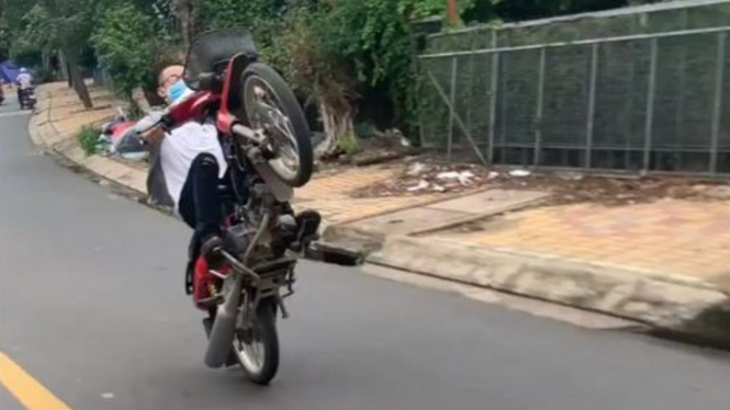 Pemotor melakukan atraksi di jalan raya