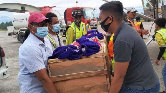 Keluarga mengangkat peti jenazah Rusman, tukang ojek yang dibunuh di Papua.