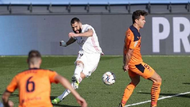 Karim Benzema dmencetak gol ke gawang Valencia