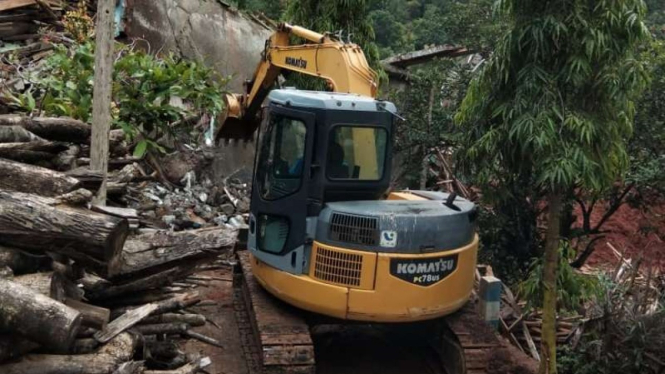 Alat berat Eksavator bergerak ke lokasi longsor dengan akses yang sulit di Dusun Selopuro, Ngetos, Nganjuk, Jawa Timur.