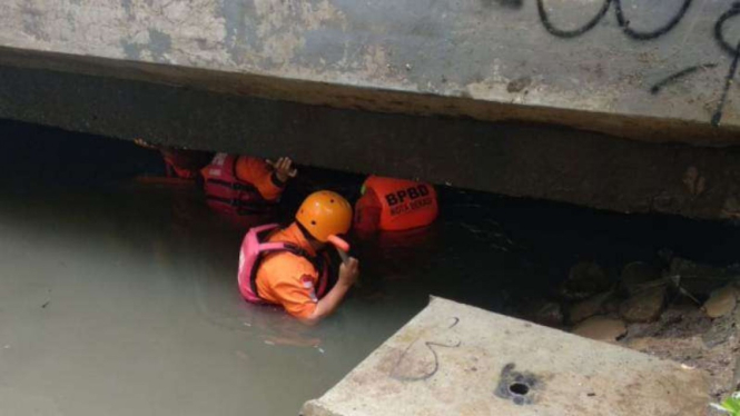 Petuas dari BPBD Kota Bekasi saat mencari korban, DDB, yang terseret arus.