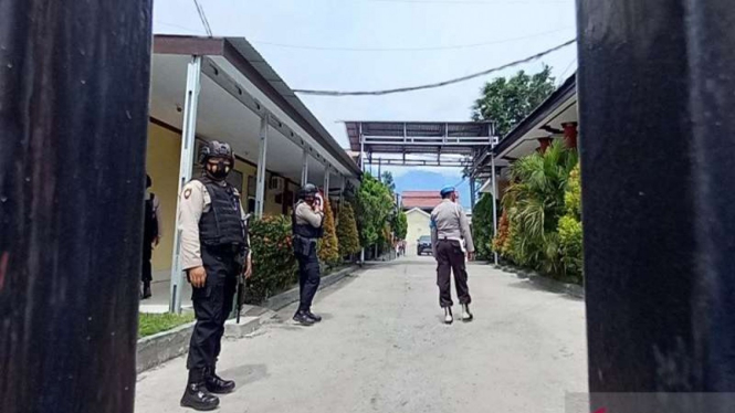 Polisi bersenjata lengkap berjaga saat kedua jenazah tiba di RS Bhayangkara Palu