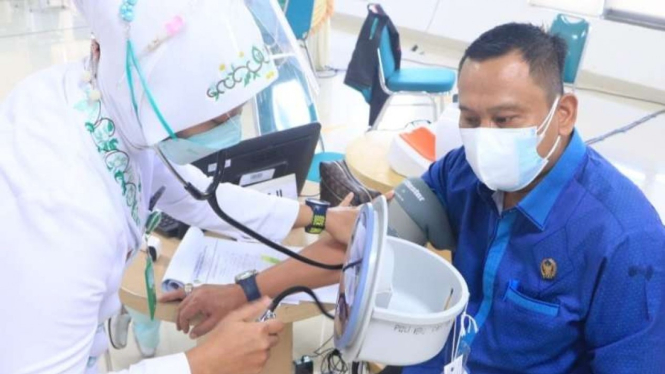 Anggota DPRD Depok, Hamzah diperiksa kesehatannya sebelum divaksin.