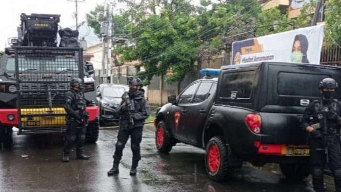Petugas bersenjata lengkap mengamankan lokasi penemuan paket kardus di Makassar.