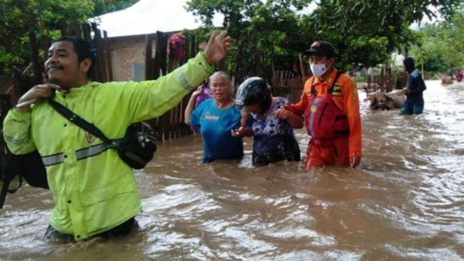 Tim Basarnas mengevakuasi warga terdampak banjir di Kabupaten Bima.