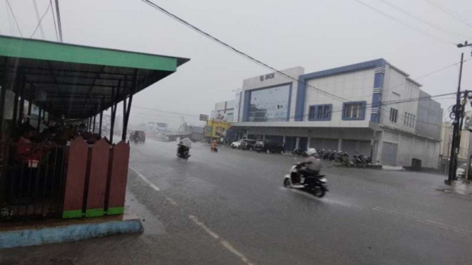 Potret aktivitas di Jalan Trikora Wosi Manokwari di tengah hujan deras dan petir, Selasa, 13 April 2021.