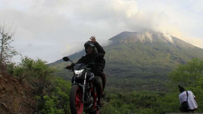 Dokumen: Seorang pengendara bermotor melintas di depan gunung Ili Lewotolok yang masih mengeluarkan material Vulkanik di desa Jontona, Kecamatan Ile Ape Timur, Kabupaten Lembata, NTT, Rabu, 2 Desember 2020.