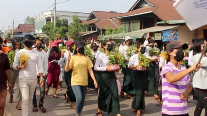 Warga berdemonstrasi sambil membawa pot Thigyan dengan bunga padauk saat mereka memprotes kup militer di Dawei, Myanmar, Selasa, 13 April 2021, dalam gambar yang didapatkan dari video.