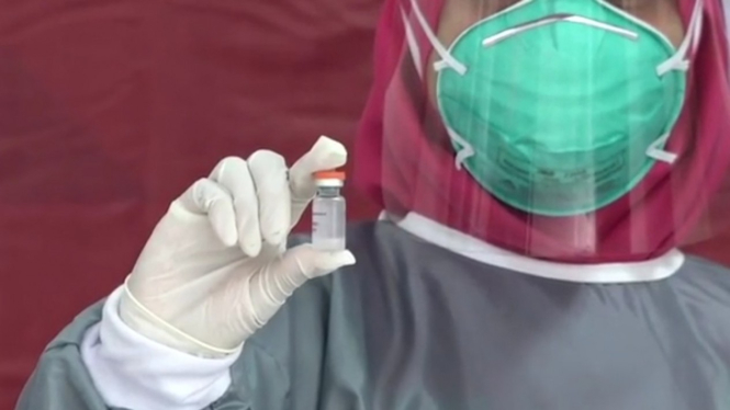 Ilustrasi seorang tenaga medis memperlihatkan dosis vaksin COVID-19 buatan Sinovac.