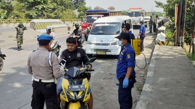 Petugas memeriksa pengendara yang melintas di Kota Tangerang
