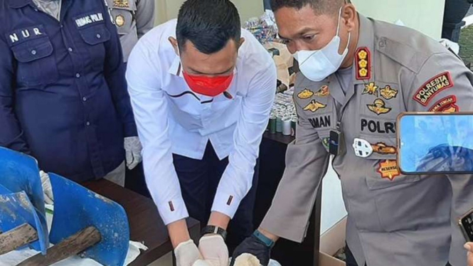 Kepala Polresta Banyumas Kombes Pol M Firman L Hakim menunjukkan gula rafinasi murni yang berwarna putih cerah dan gula rafinasi yang dioplos molase sehingga menyerupai gula pasir di kantornya, Kamis, 22 April 2021.