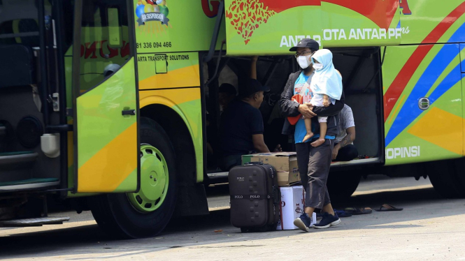 Pemudik menggunakan transportasi umum bus.