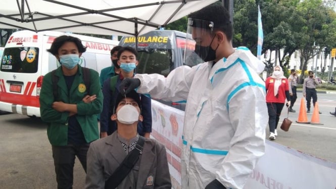 Sejumlah peserta aksi buruh mengikuti tes usap antigen di kawasan Silang Monas.