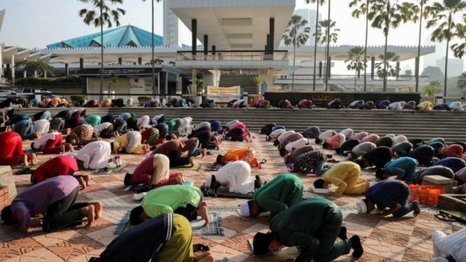 Umat Muslim melakukan ibadah salat Idul Fitri di luar Mesjid Nasional yang ditutup di Kuala Lumpur, Malaysia.