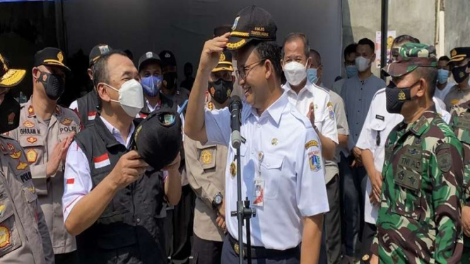 Gubernur DKI Jakarta Anies Baswedan bertukar topi dinas dengan pak RW di Sunter