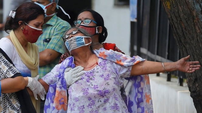 Seorang perempuan berduka setelah melihat jenazah putranya yang meninggal akibat Covid-19 di New Delhi, India. BBC Indonesia