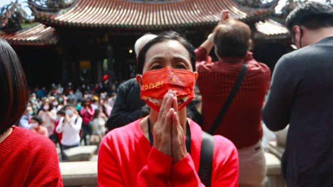 Warga Taiwan berdoa sambil memakai masker di Kuil Lungshan. BBC Indonesia