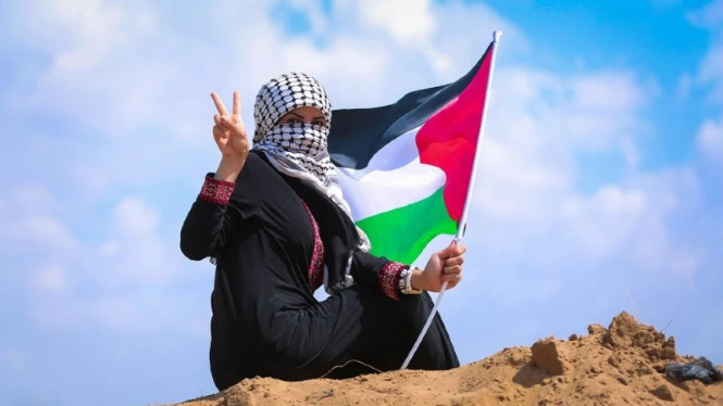 Seorang wanita mengibarkan bendera Palestina di Jalur Gaza.