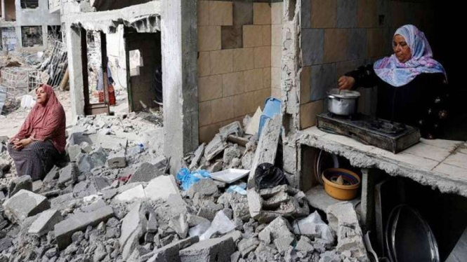 Warga Palestina di tengah puing-puing rumah yang hancur