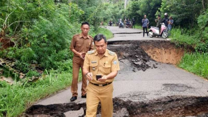 Camat Sosoh Buay Rayap Amin Baladi memeriksa kondisi jalan putus akibat pergeseran tanah di Desa Kungkilan, Kecamatan Sosoh Buay Rayap, Kabupaten Ogan Komering Ulu, Sumatera Selatan, Selasa, 25 Mei 2021.