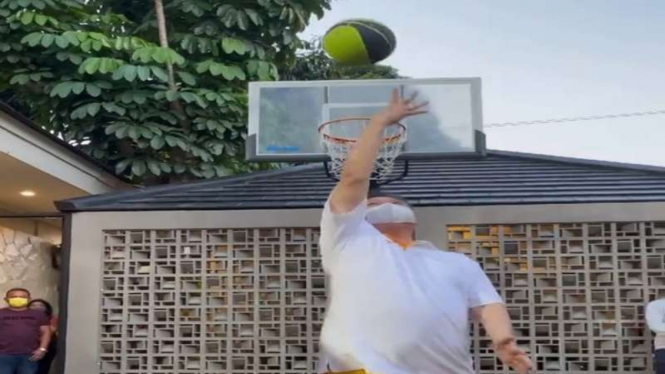 Aksi Airlangga Hartarto melempar bola basket dengan membelakangi ring