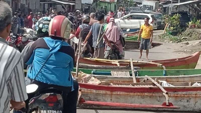 Sejumlah nelayan di Desa Gamo, Kecamatan Gunungsitoli, Kota Gunungsitoli, Sumatera Utara, memblokir jalan dengan menempatkan perahu di tengah jalan provinsi, Jumat, 4 Juni 2021.