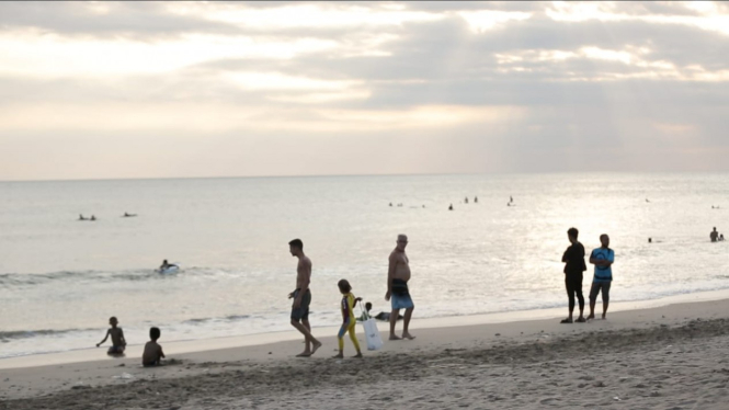 wisatawan sedang bermain di pantai Kuta Bali.