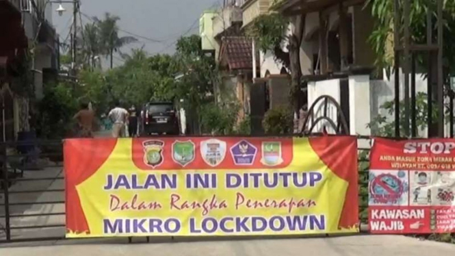 Pintu gerbang Perumahan Villa Mutiara Gading di Kelurahan Setia Asih, Tarumajaya, Kabupaten Bekasi, Jawa Barat, ditutup dan dijaga ketat, Selasa, 8 Juni 2021, setelah 24 warga di sana positif terinfeksi COVID-19.