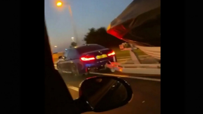 BMW M5 balapan sembari menarik kapal.