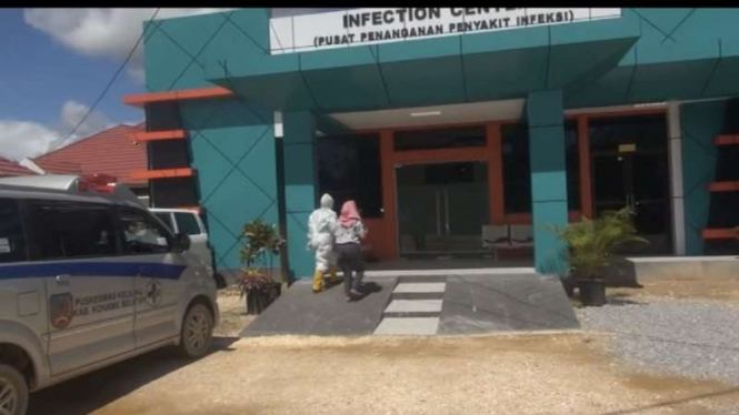 Petugas medis mendampingi seorang wanita yang diduga terinfeksi COVID-19 memasuki gedung Pusat Penanganan Penyakit Infeksi RSUD Kota Kendari, Sulawesi Tenggara, Jumat, 25 Juni 2021.