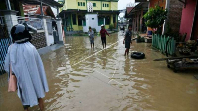 Warga disekitar rumahnya yang terendam banjir di Kampung Baru di Palu, Sulteng.