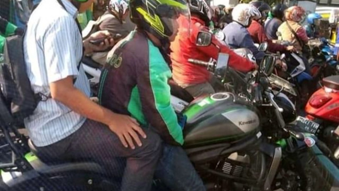 Ojol bawa penumpang naik motor Kawasaki Vulcan.